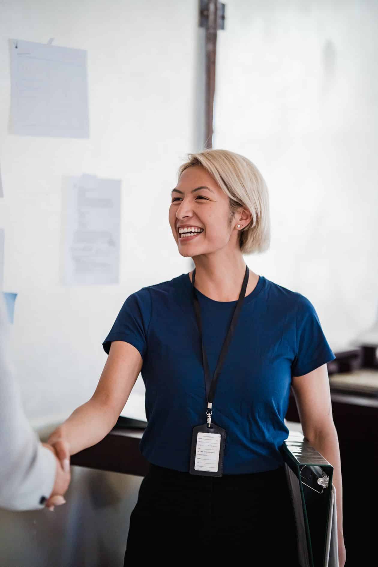 Smiling woman shaking hands with a colleague after a successful raise conversation