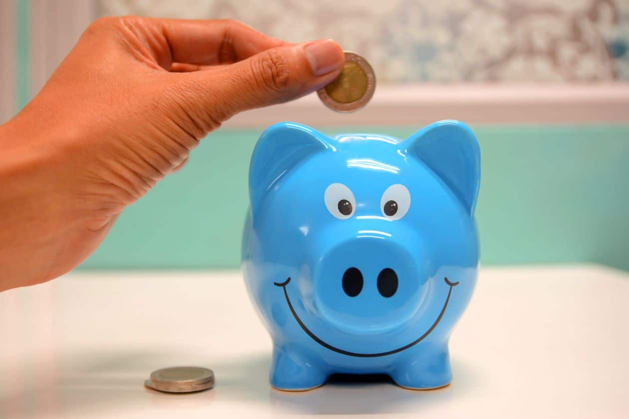 Woman putting a coin into a piggy bank to build savings