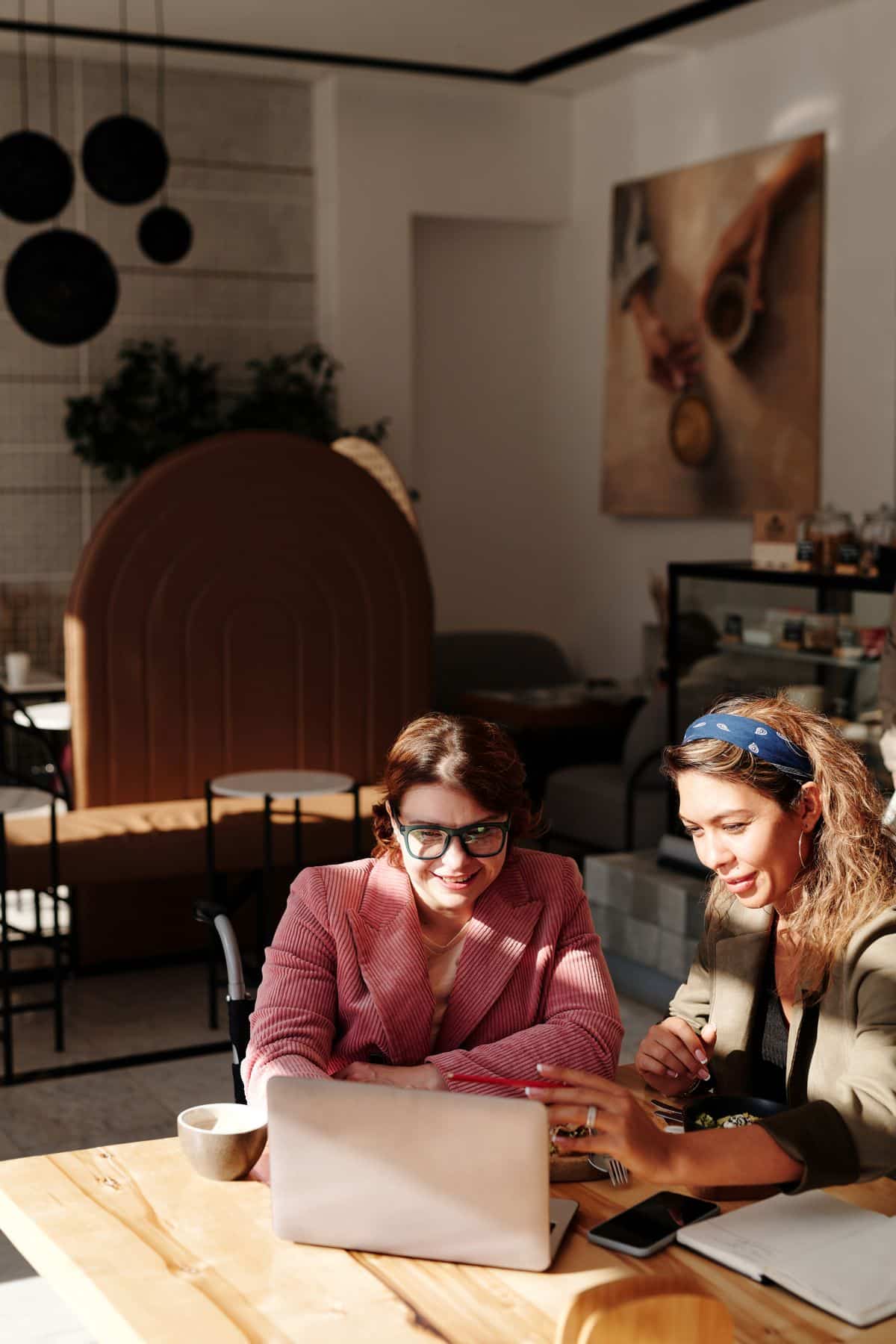 Two women in a warm coaching conversation over coffee