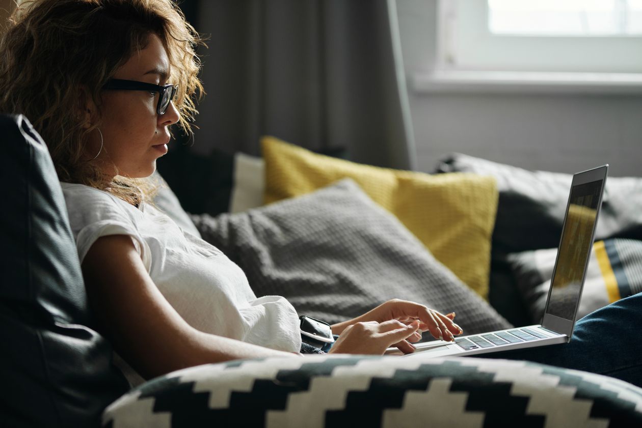 Woman using her laptop to compare accreditation and cost across online degree programs