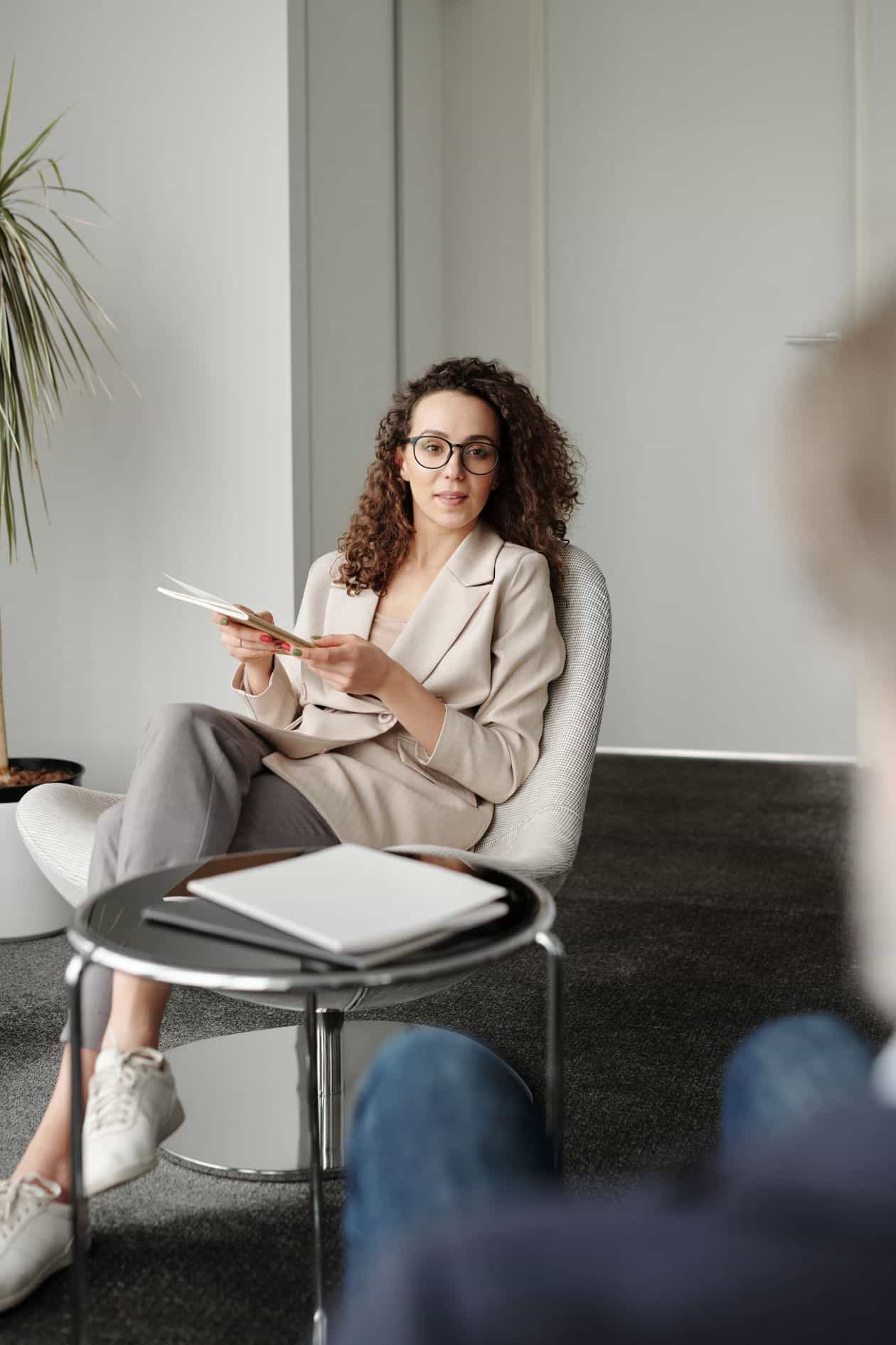 Confident woman in a beige suit sitting at a table