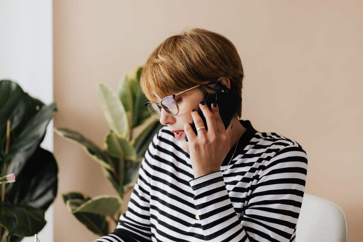 Serious businesswoman having a phone conversation in a light workplace