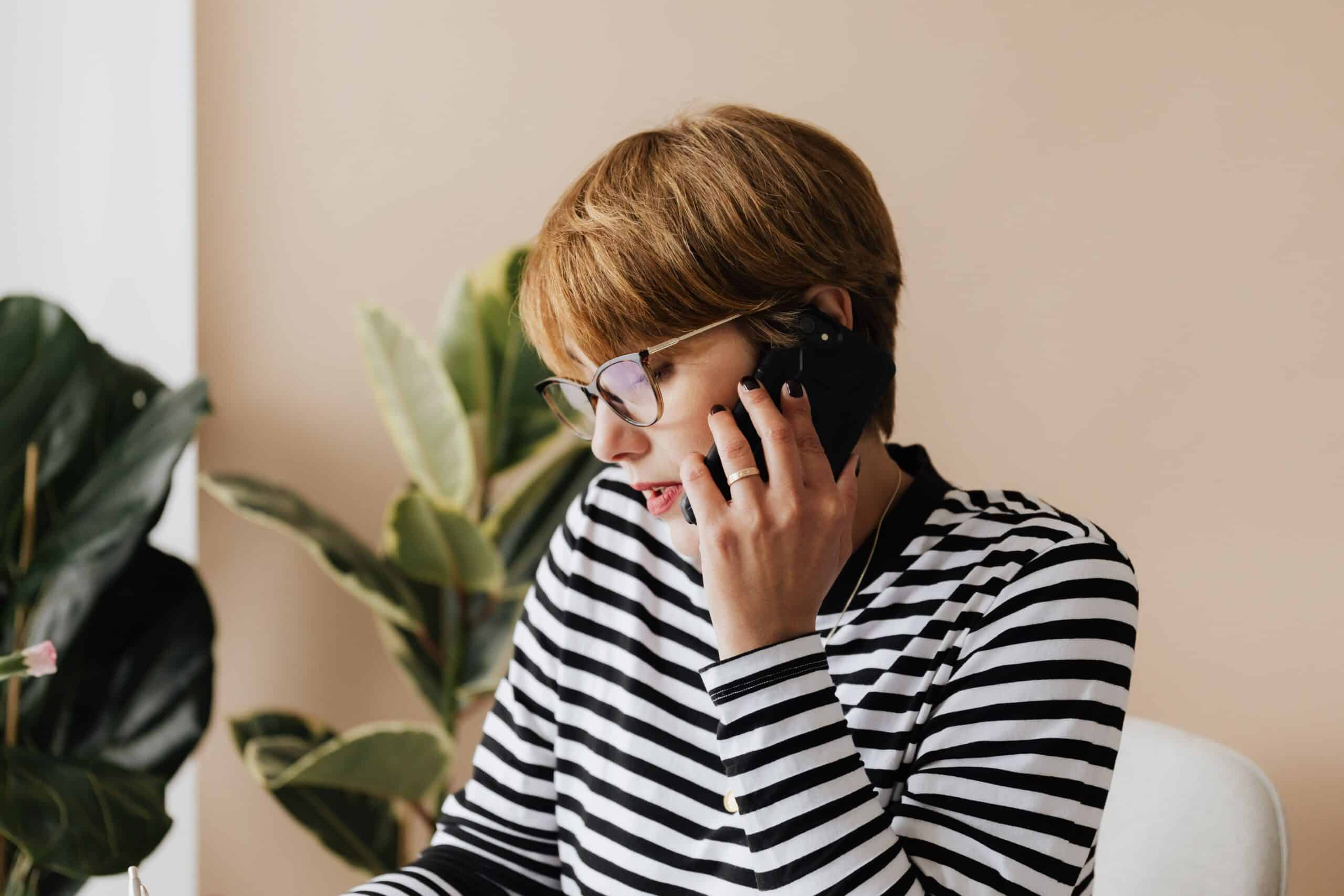 Serious businesswoman on the phone, consulting an employment attorney