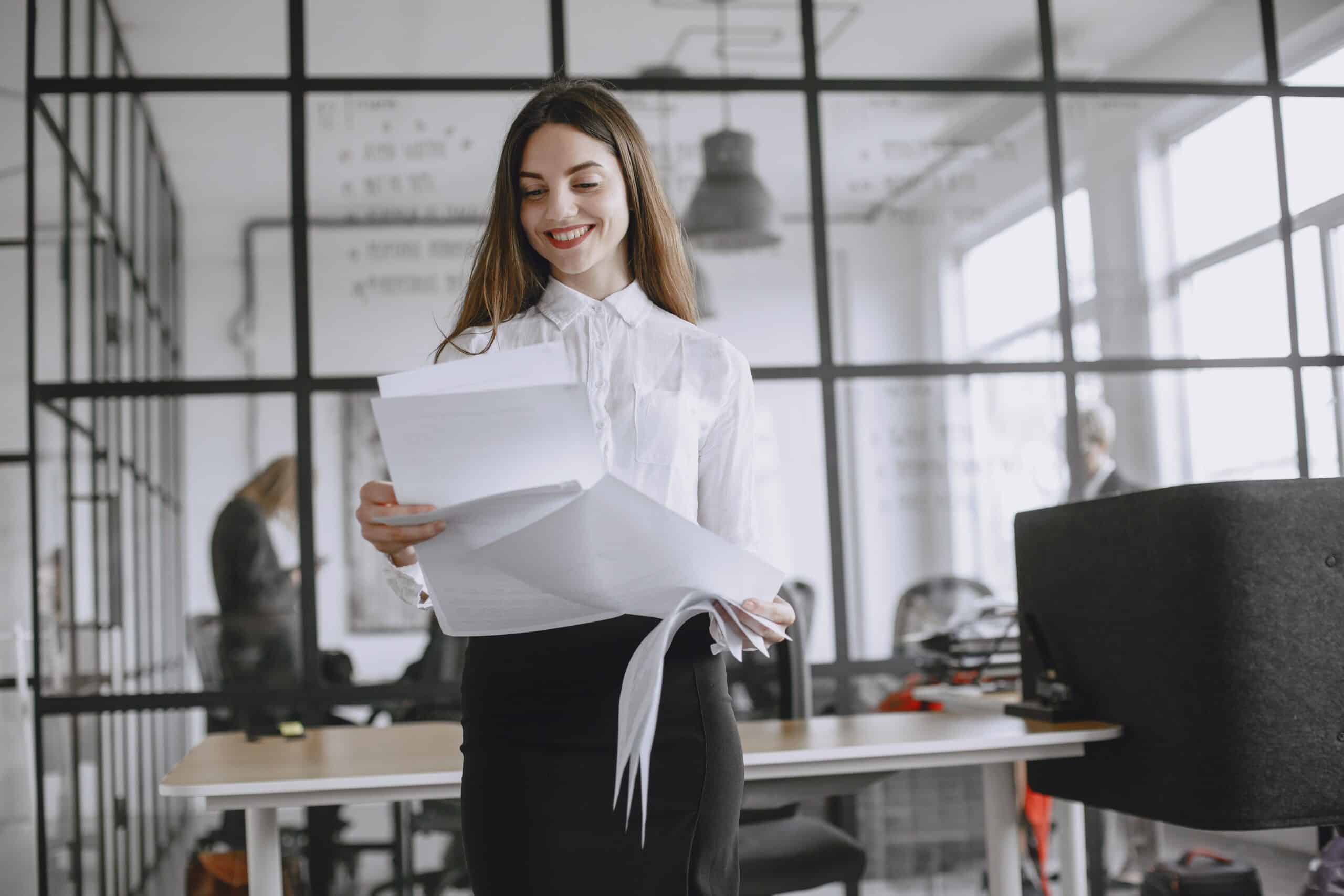 Woman reviewing documents confidently at her office desk