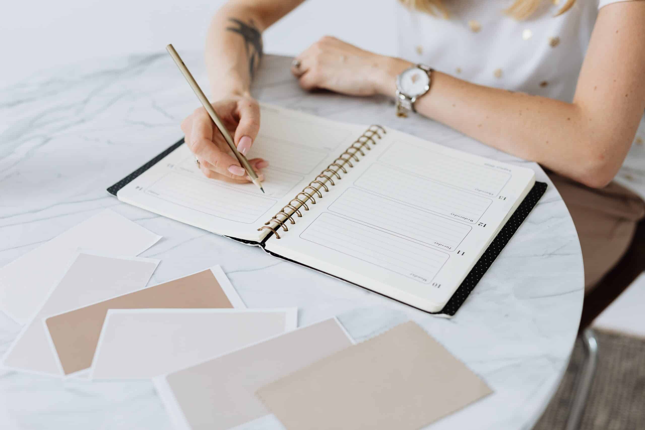 Woman writing in a planner, mapping out first steps toward a career change