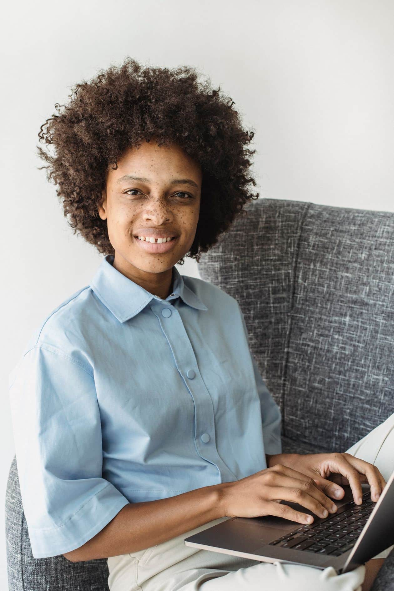Woman working comfortably on her laptop at home, evaluating a legitimate work-from-home offer