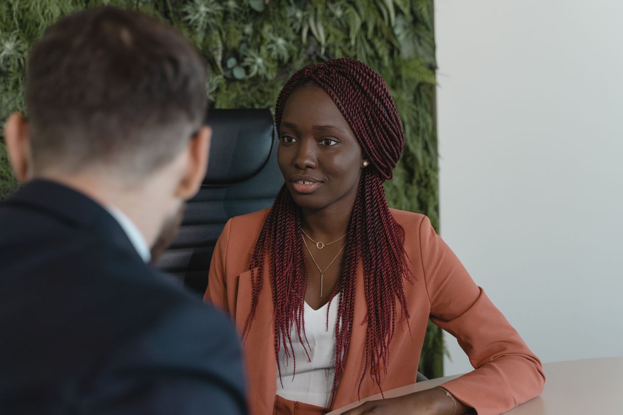 Woman in corporate attire listening carefully in an office chair