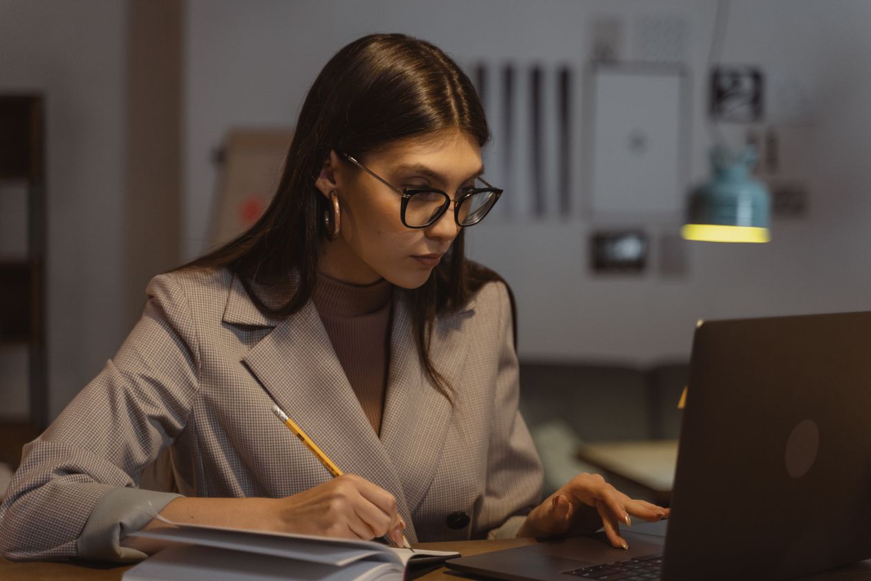 Woman in a blazer using a laptop, freelancing from a former career field