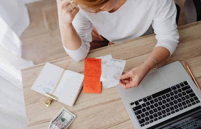 Woman sitting behind a desk looking at receipts