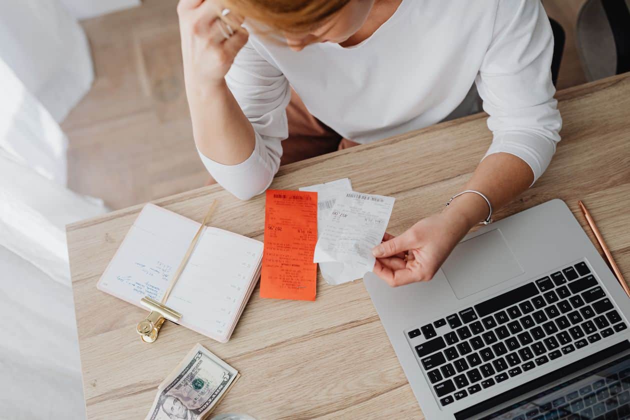 Woman sitting behind a desk looking at receipts