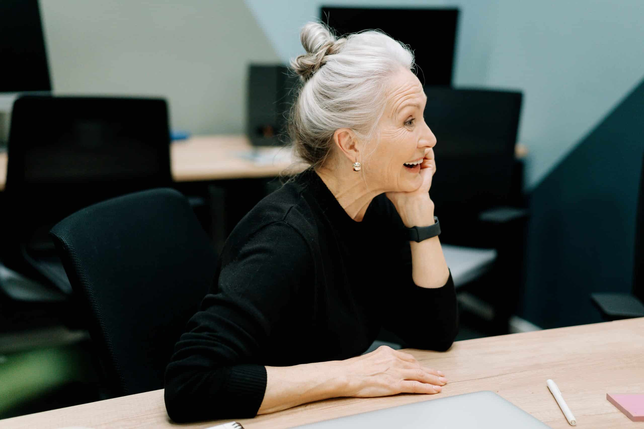 senior businesswoman smiling at her desk in a modern office