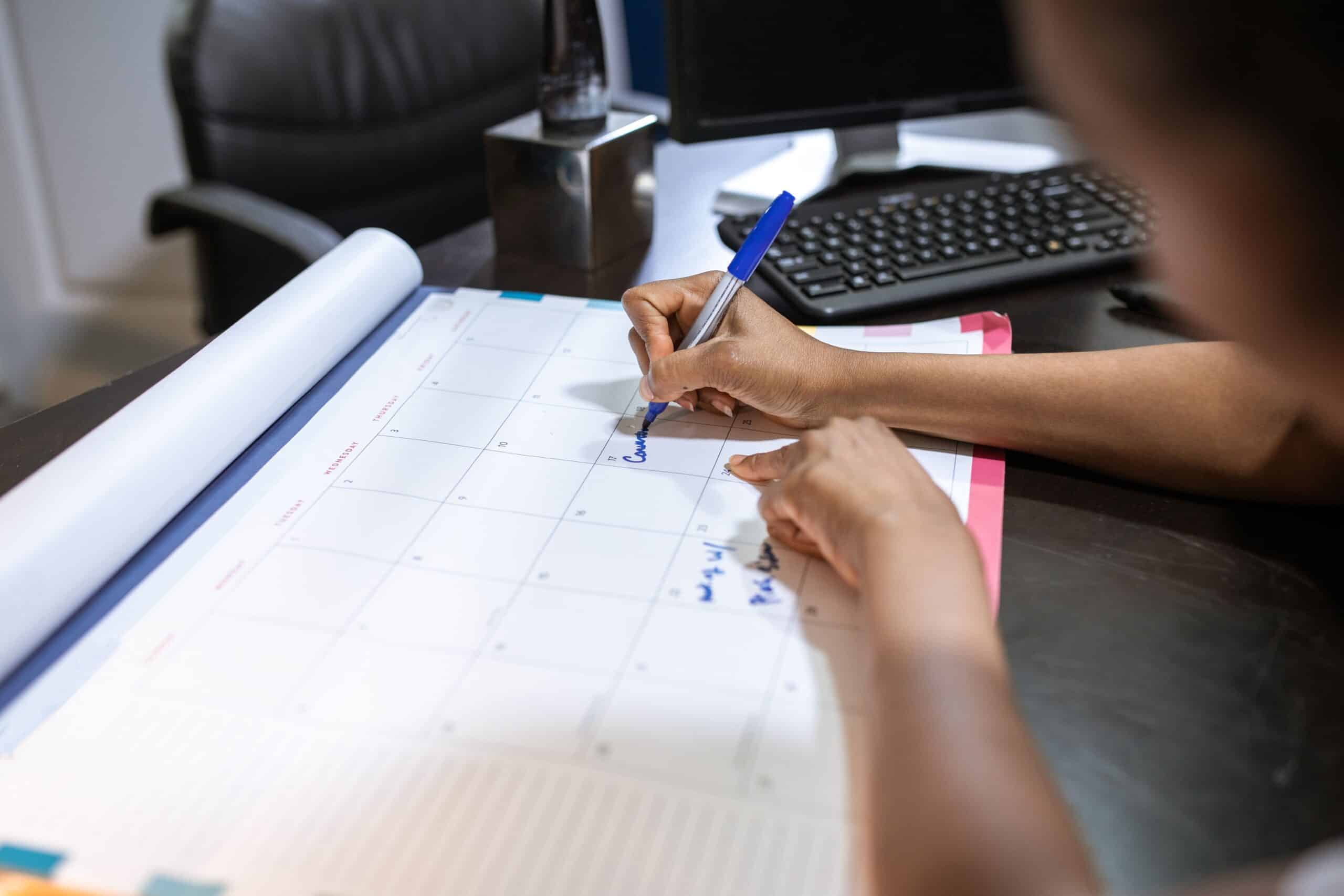 Woman planning her job search timeline on a desk calendar