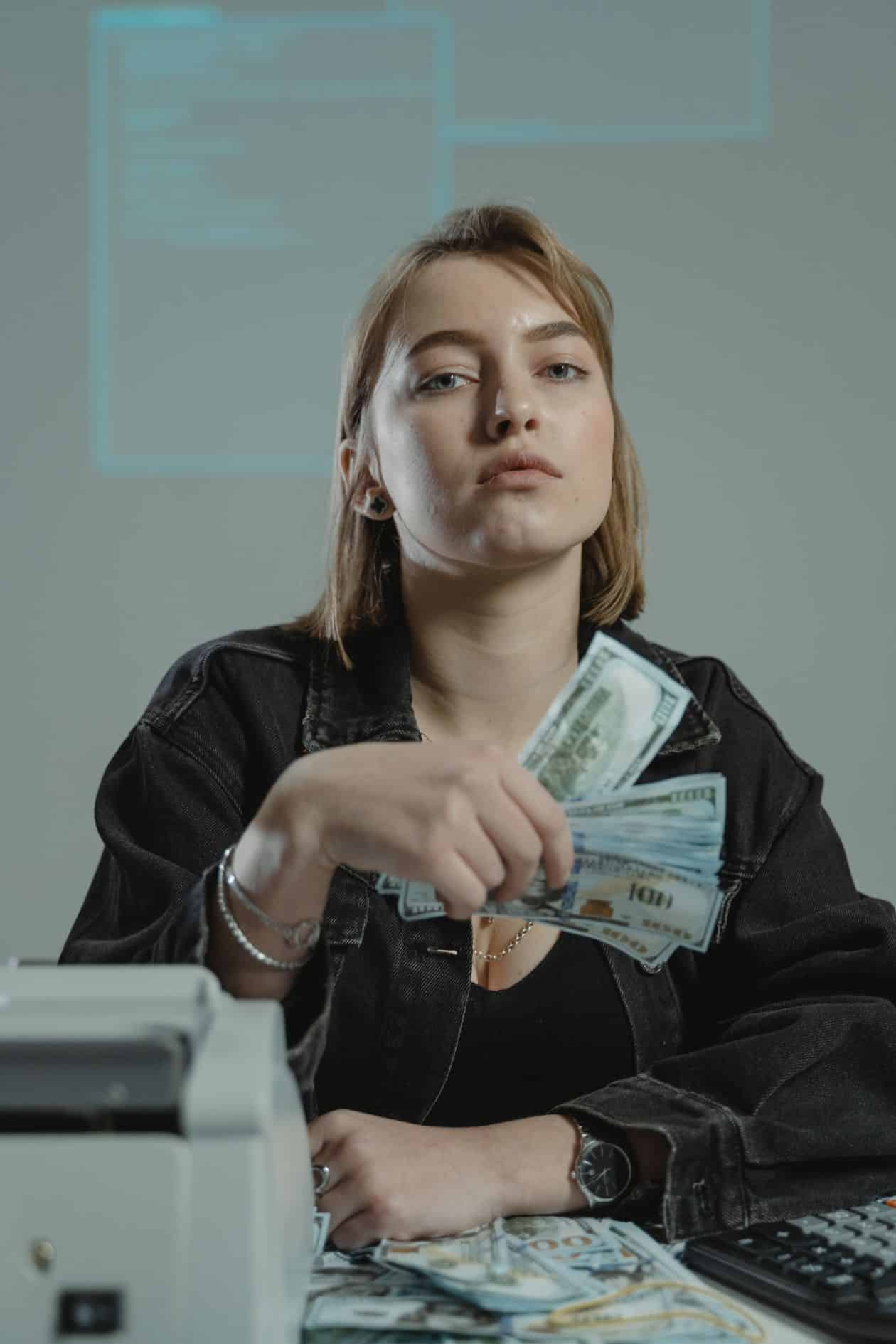 Woman holding cash while thinking through her savings and transition fund plan