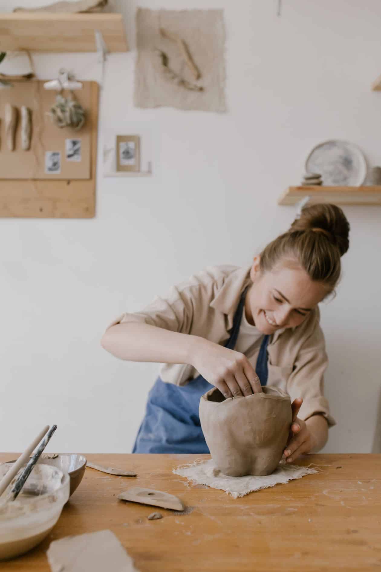 Woman doing pottery, testing demand for handmade work