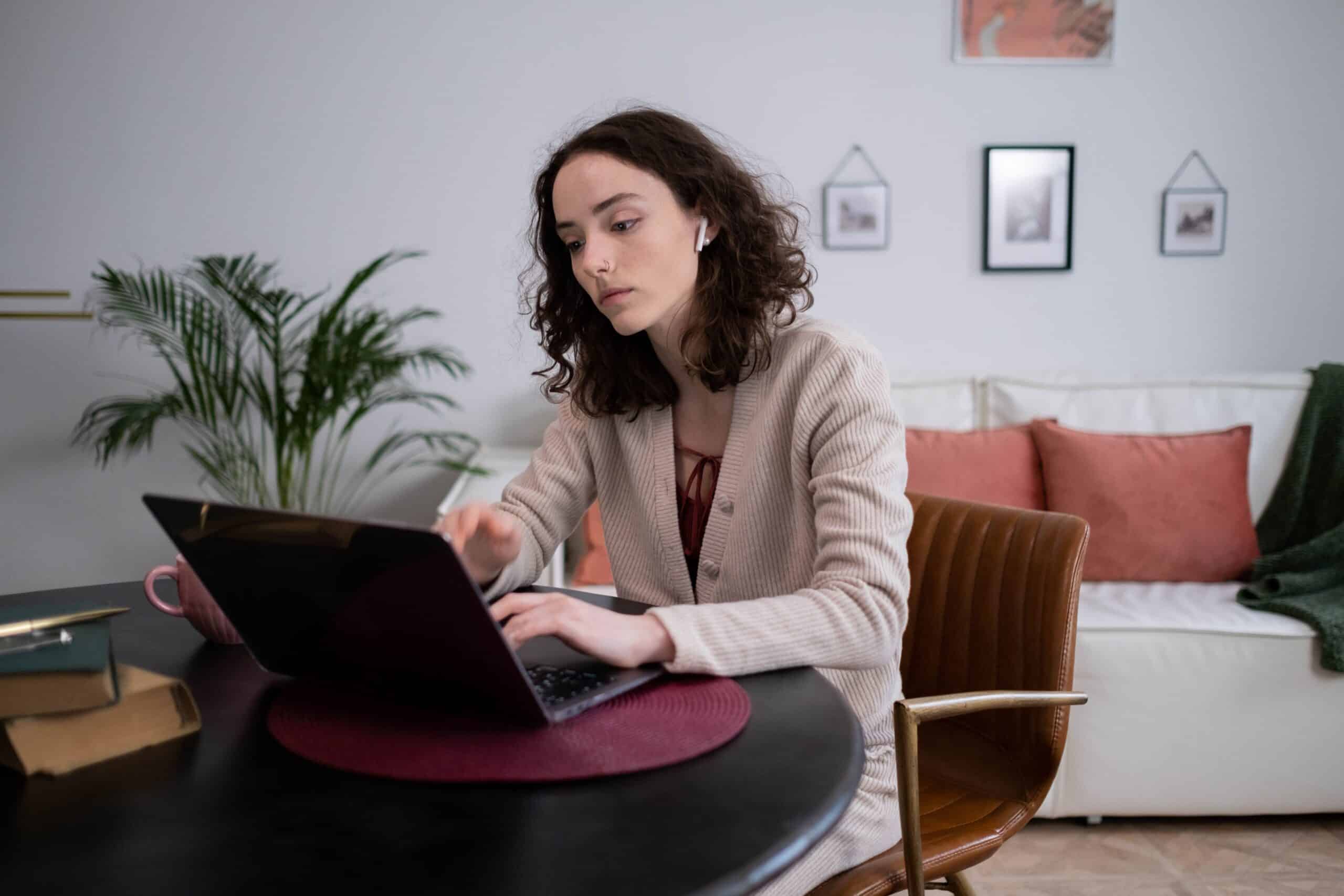 woman working remotely on her laptop in a cozy home setting
