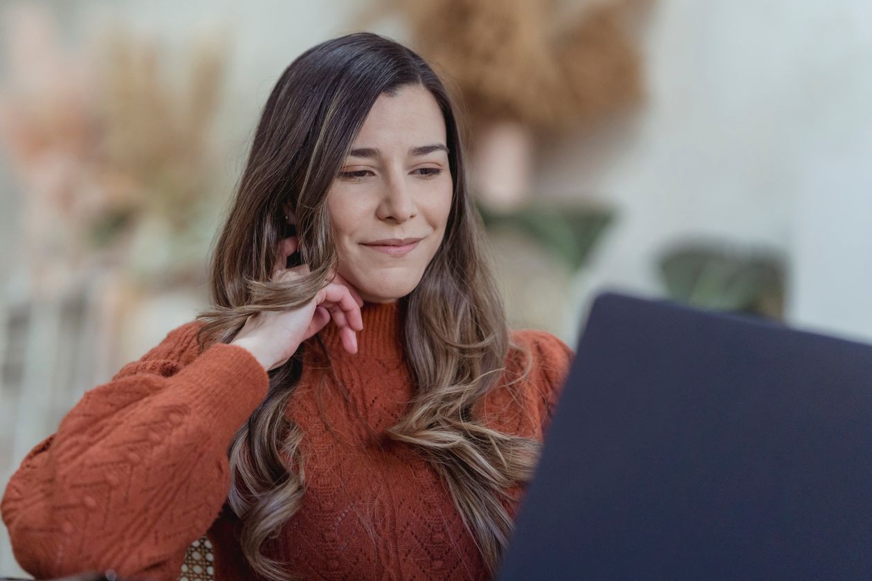 Smiling woman browsing job and client options on a laptop