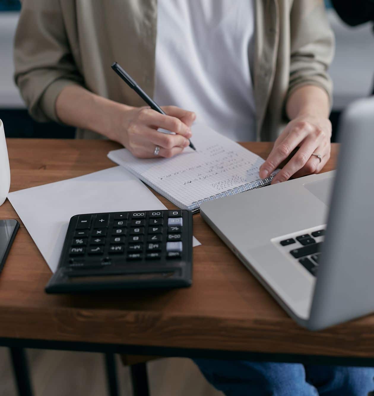 Person calculating numbers on a notebook while planning a transition timeline