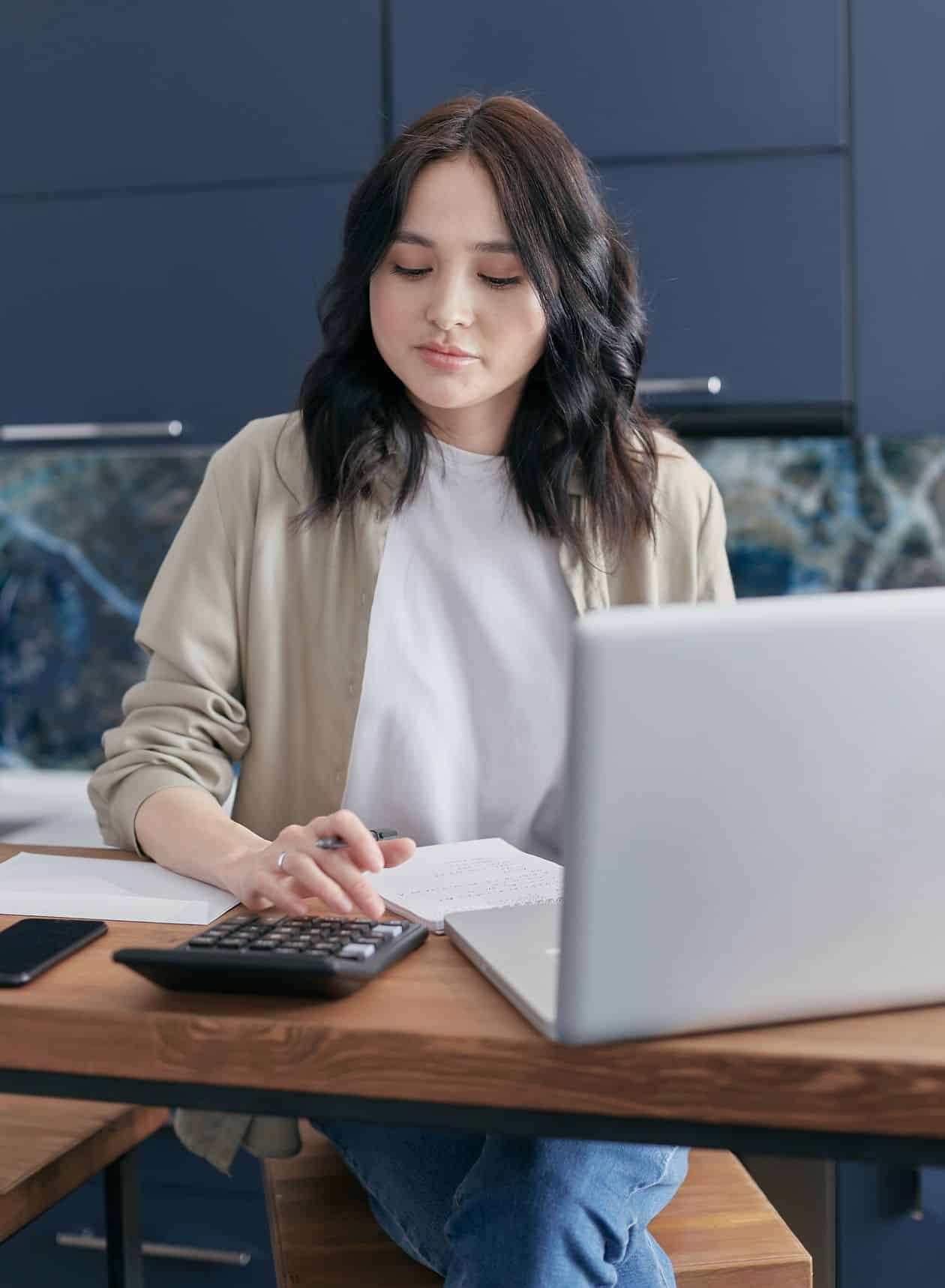 Woman in a blazer holding a laptop, weighing a career change decision