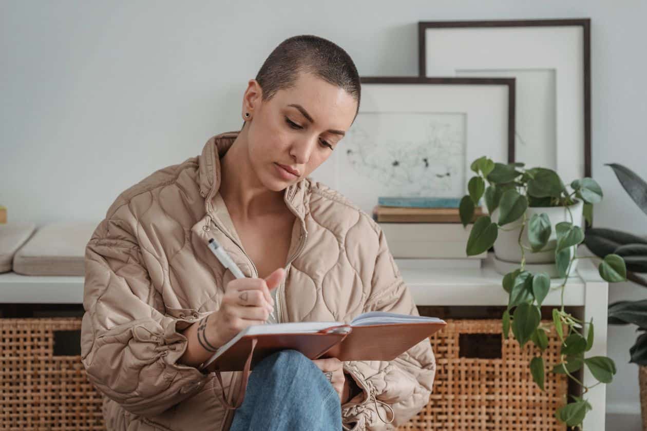 Woman taking notes while weighing the cost of staying versus changing careers