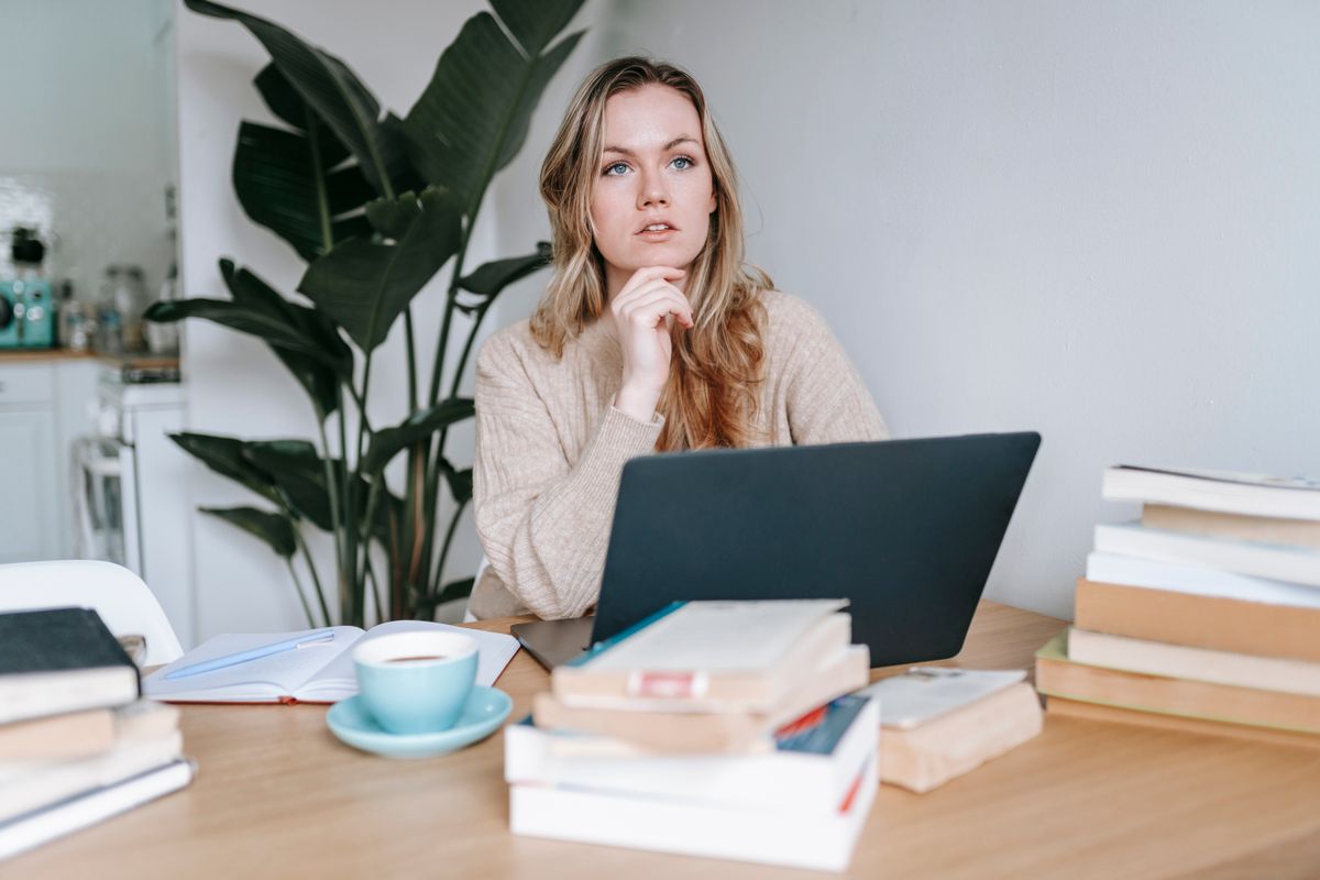 Woman thinking through her business plan on a laptop at home