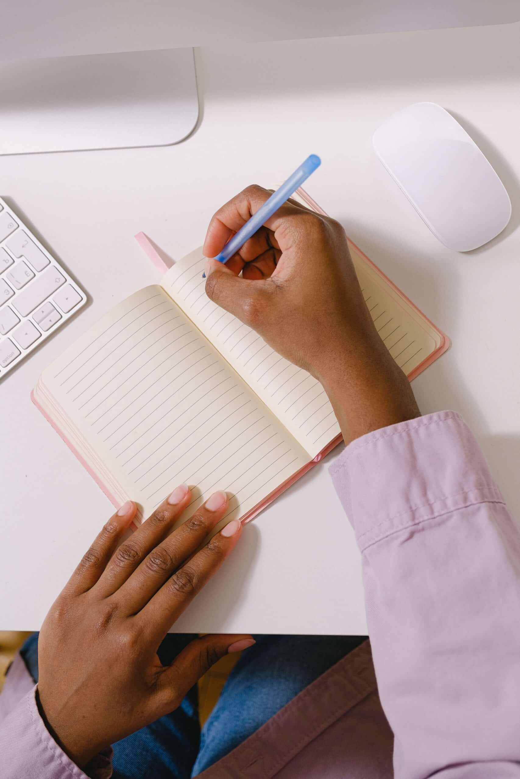 Woman taking notes in a planner from above, brainstorming second career ideas