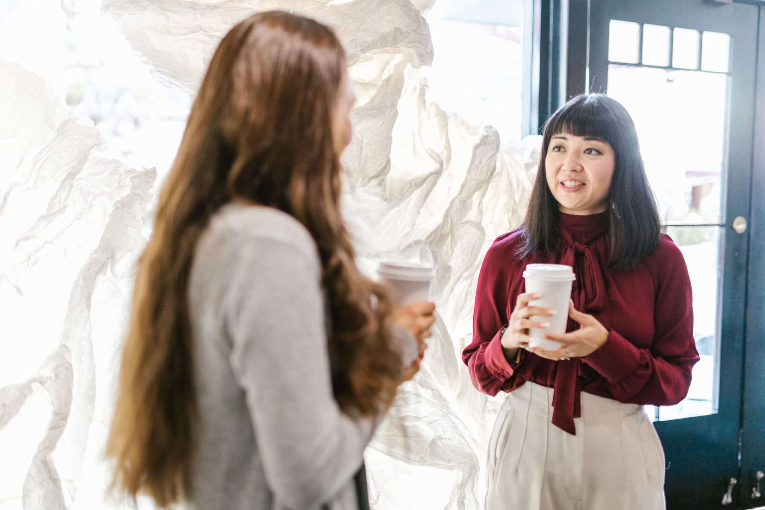 Two women reconnecting over coffee during a career conversation