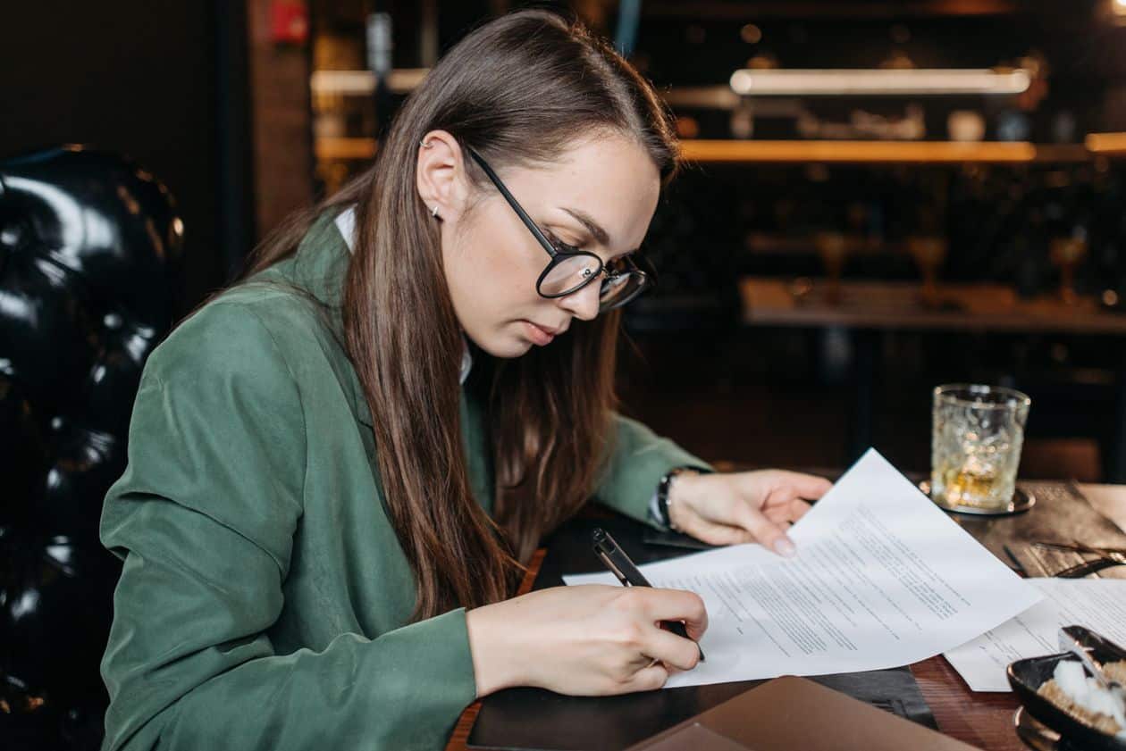 Woman signing a document after reviewing the release language closely