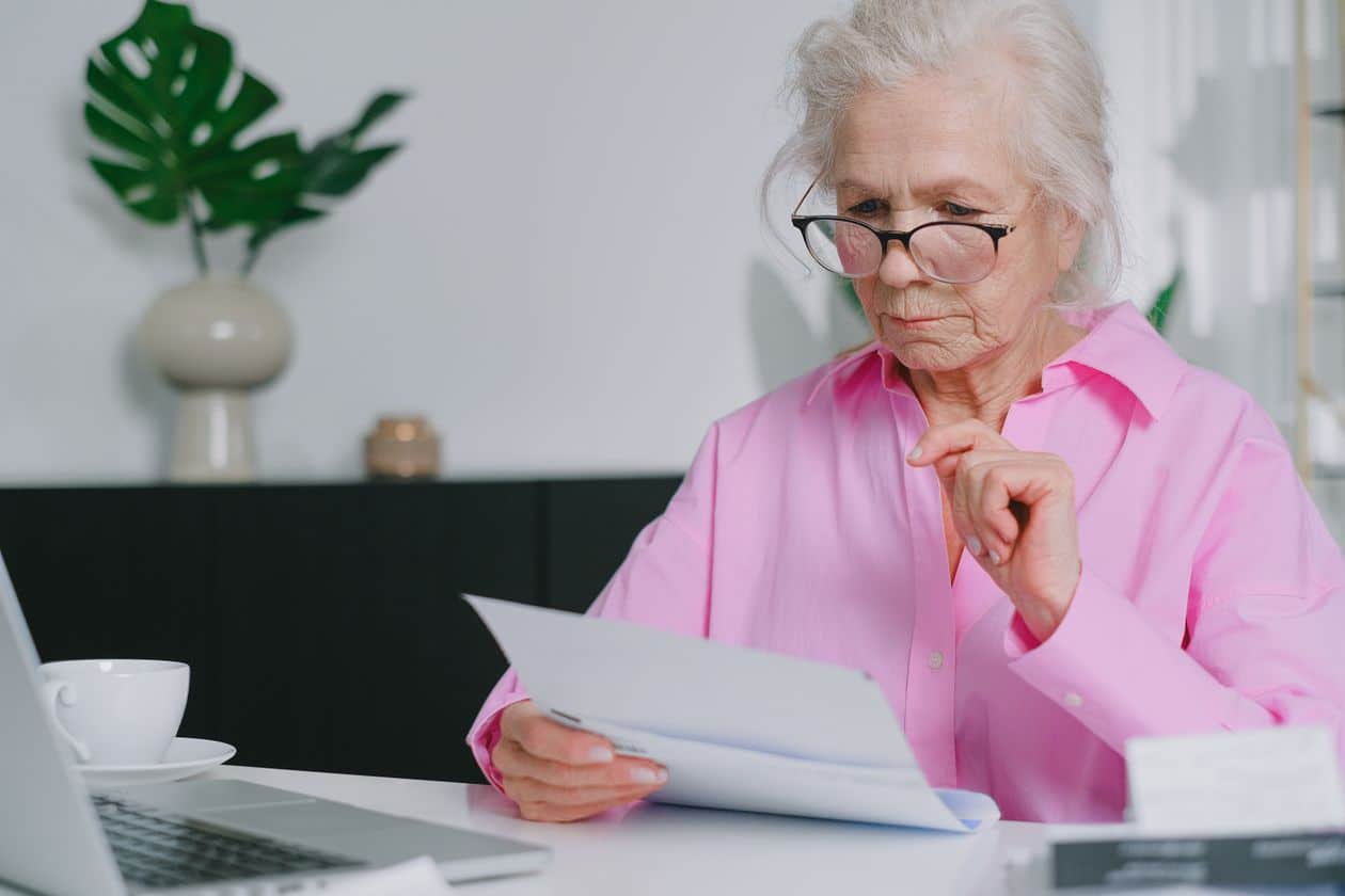 Woman sitting and reviewing paperwork while recalculating her retirement timeline