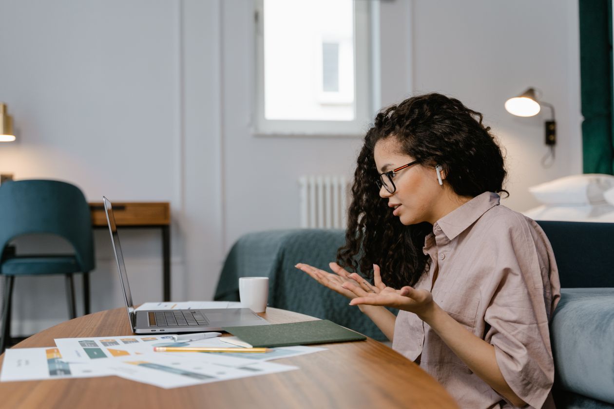 Woman at her home office desk taking a call, an example of a legitimate remote customer service role