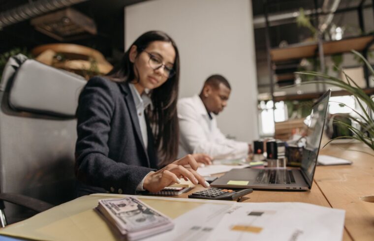Woman using a calculator at the office to run the numbers on a career change