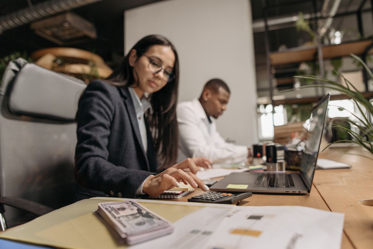 Woman using a calculator at the office to run the numbers on a career change