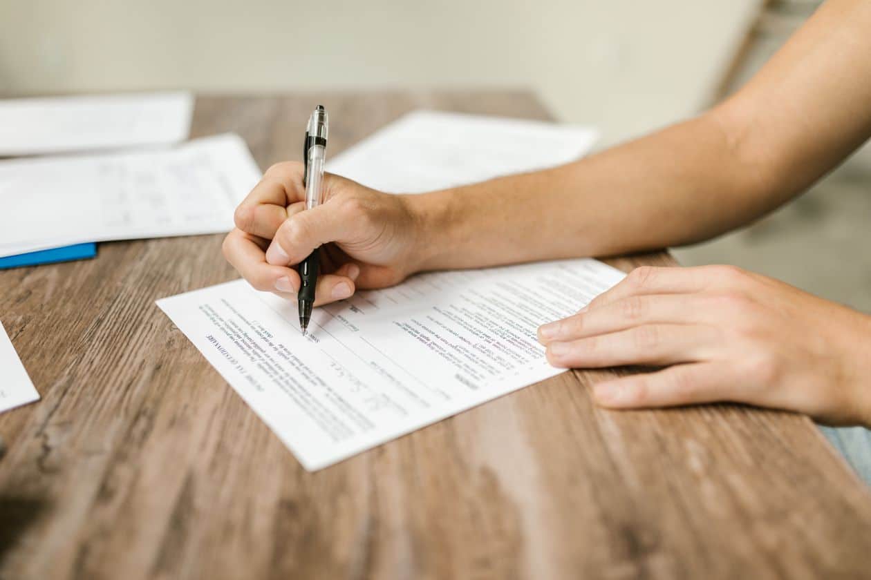 Close-up of a person filling out a grant application form