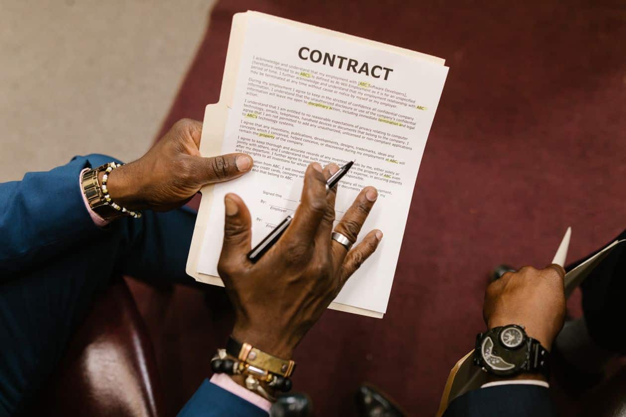 Close-up of a person holding a contract, considering an attorney review