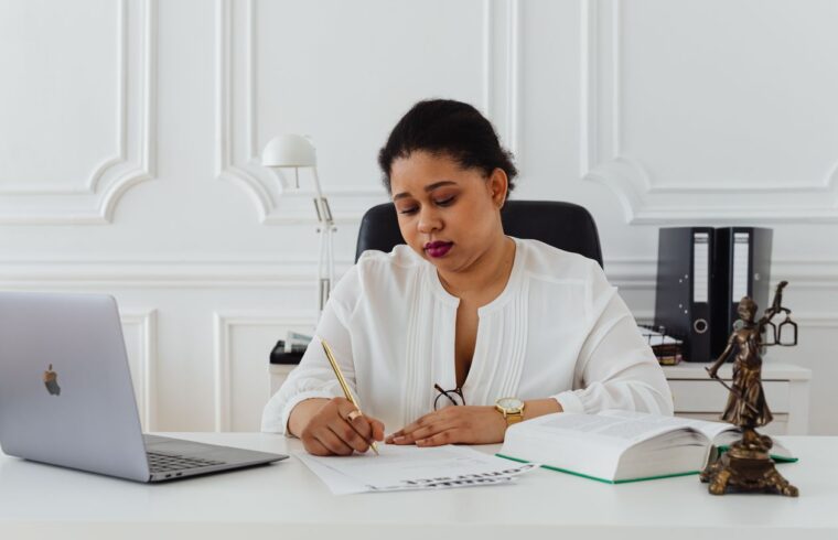 Woman at her office desk signing a severance agreement