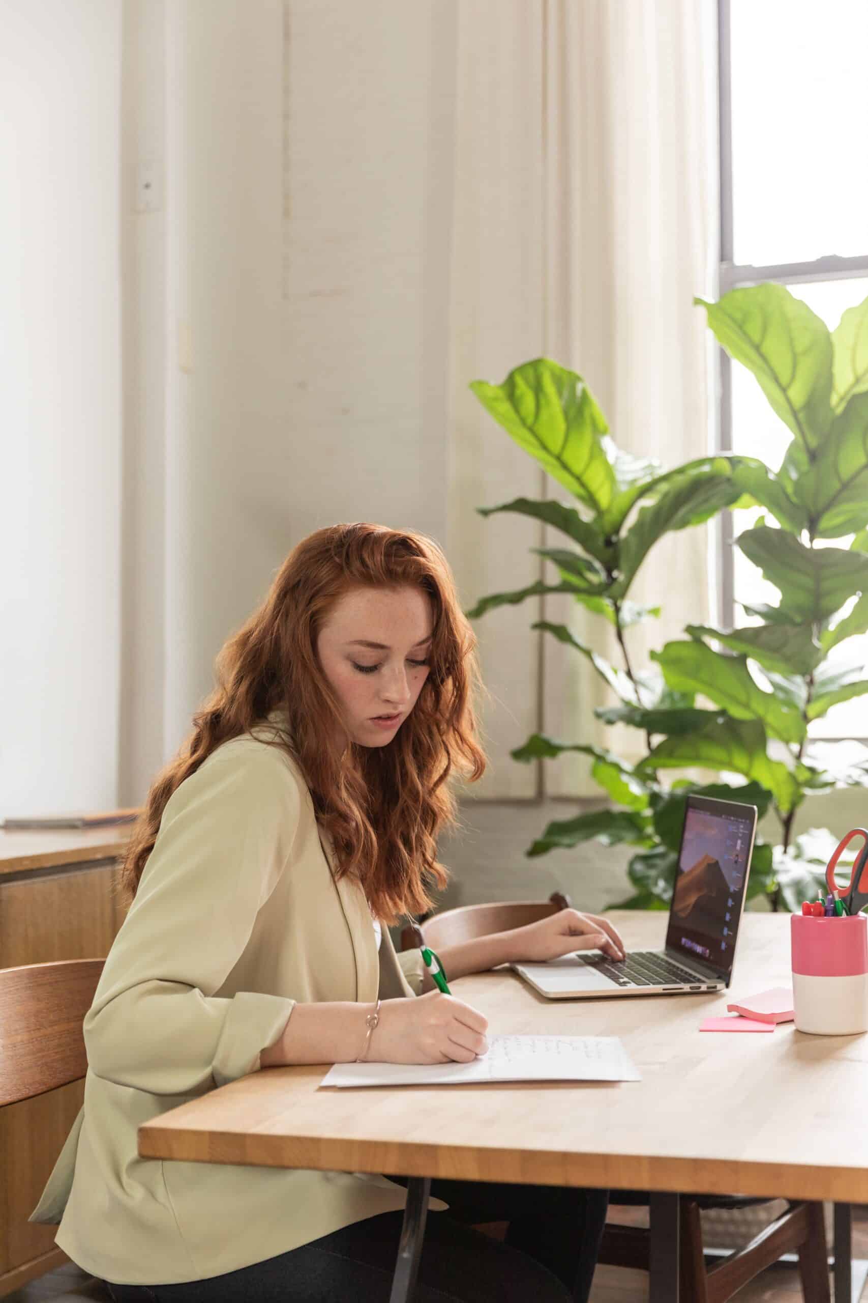 Woman typing on a laptop, updating her LinkedIn experience section