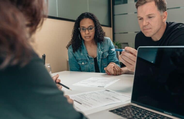 Couple listening to a person explaining financial documents