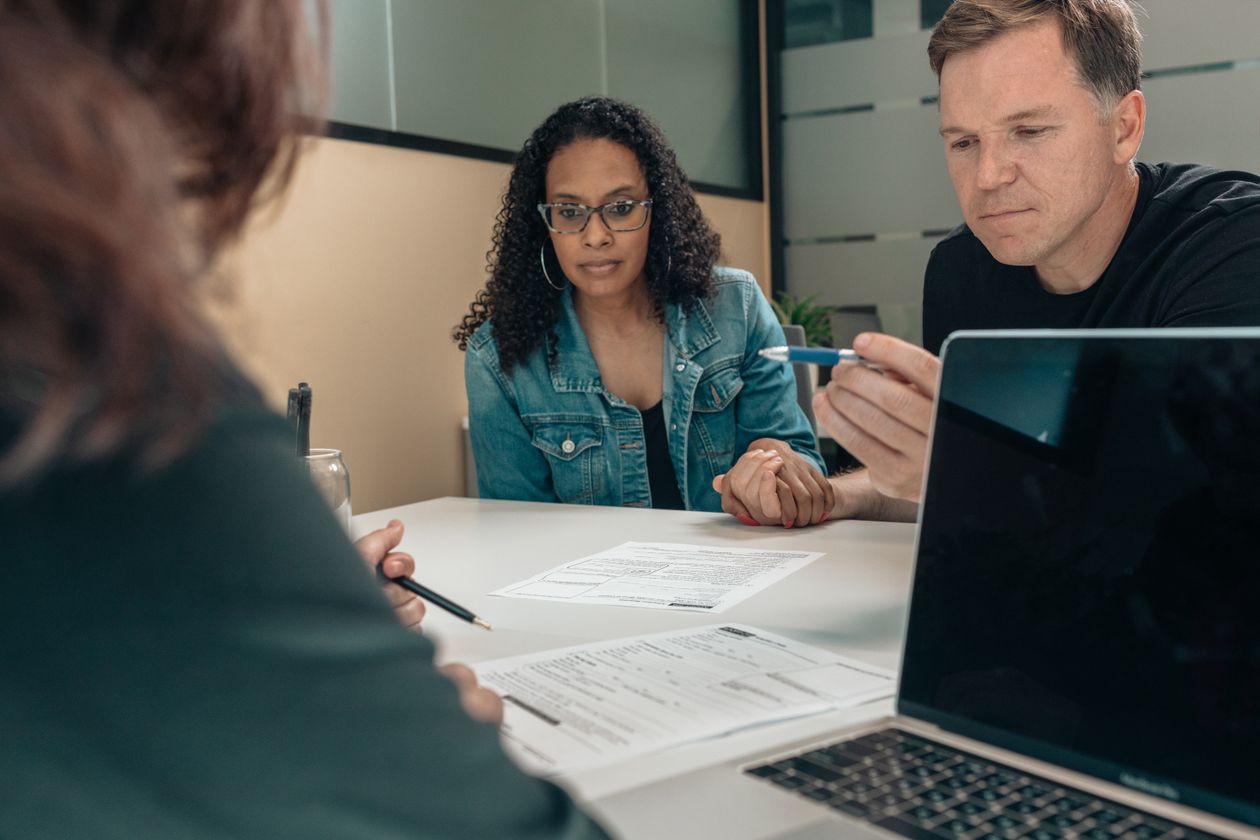 Couple listening to a person explaining financial documents