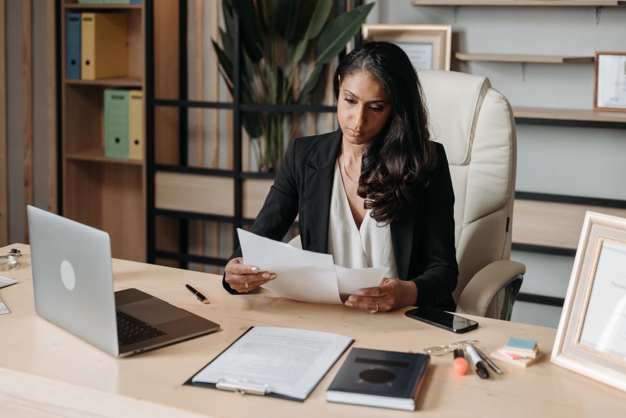 Woman working at her desk reviewing paperwork in an office