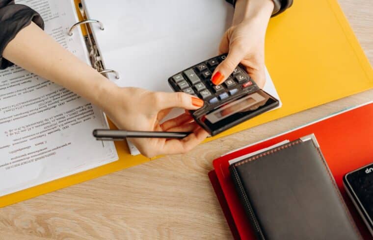Woman computing with a calculator, working out financial aid options as an adult student
