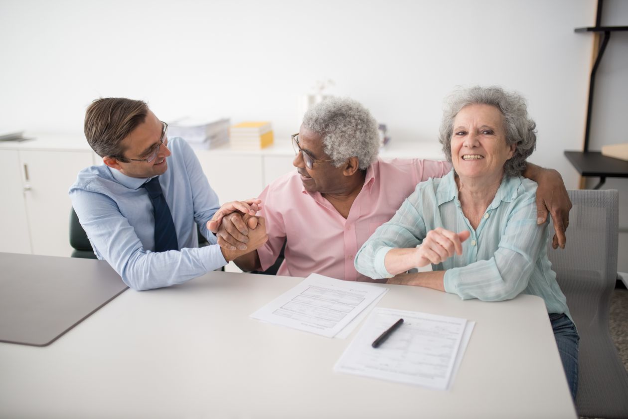 Financial advisor sitting next to smiling clients