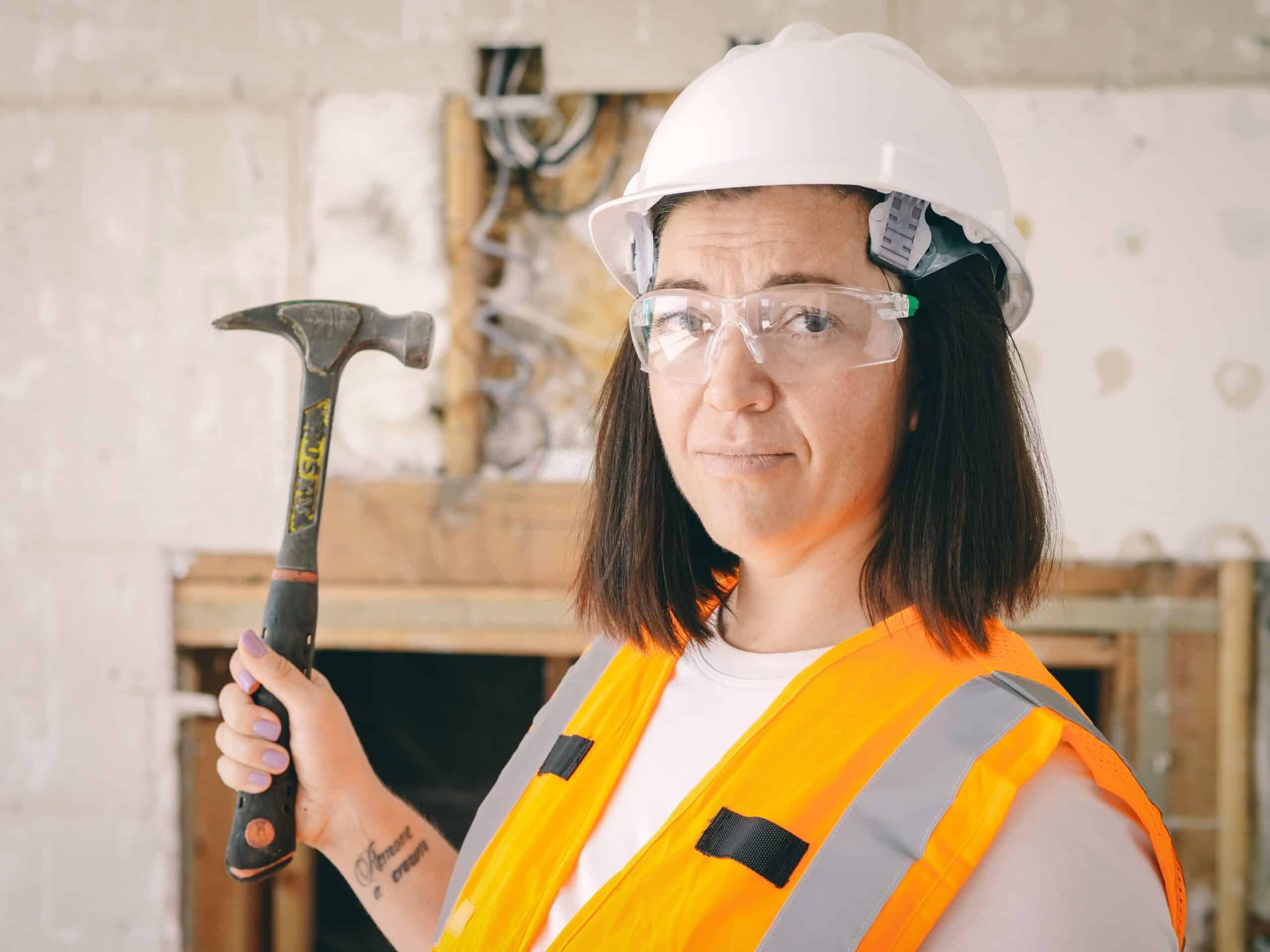 Confident woman construction worker in hard hat and vest, representing a trade career started at 40 without a degree