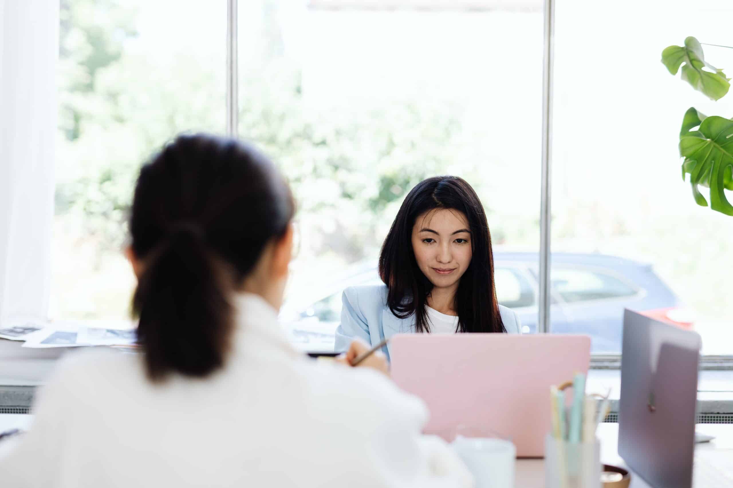 Two businesswomen having a warm, productive conversation in an office