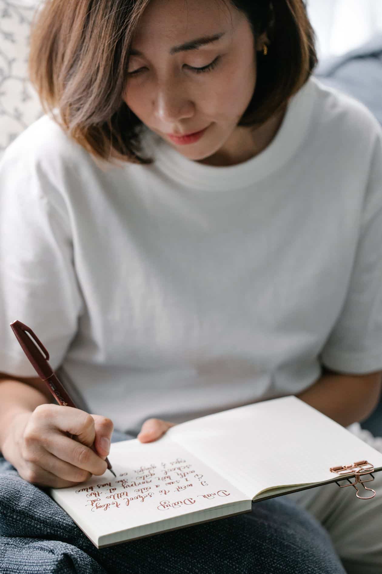Woman writing in her journal to examine her financial beliefs