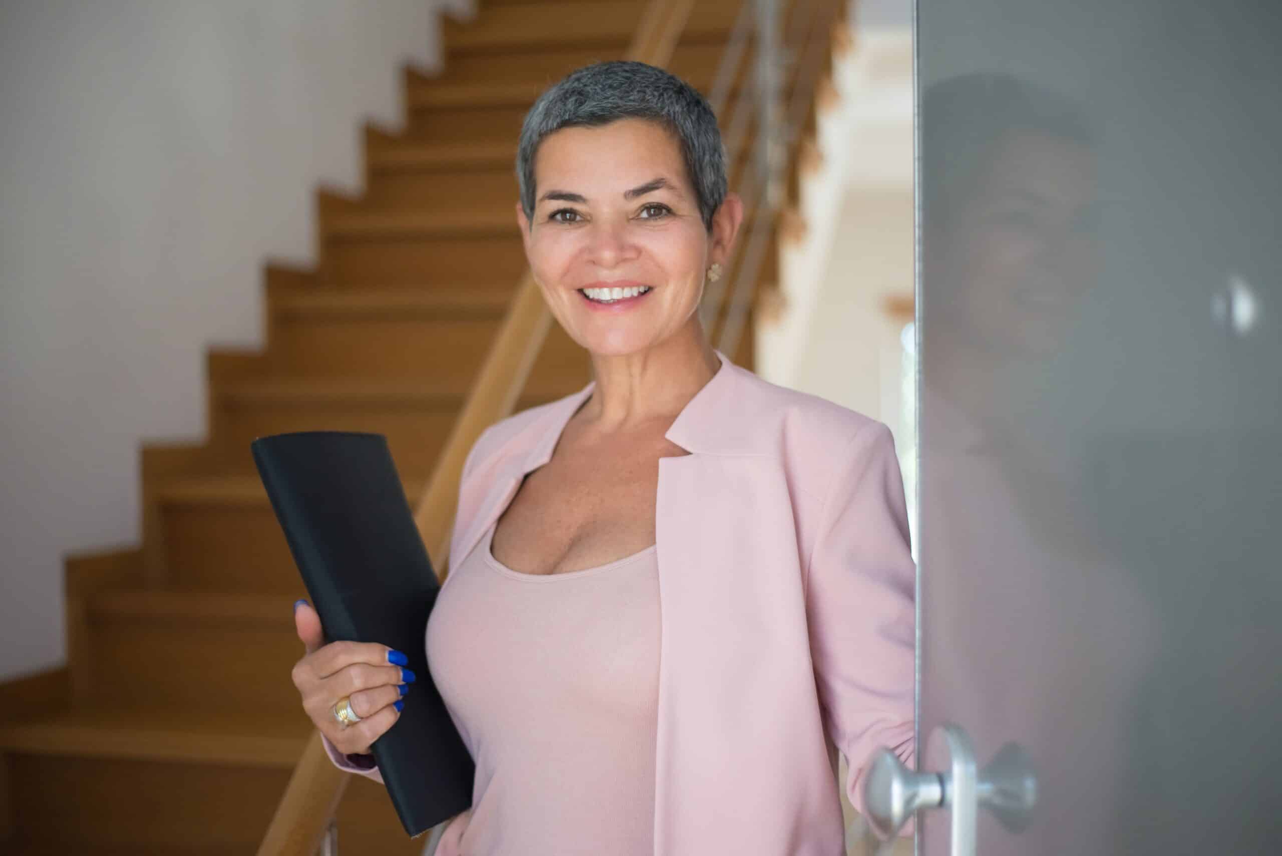 Confident woman in her 40s entering a new office, smiling, symbolizing a successful career change at 40