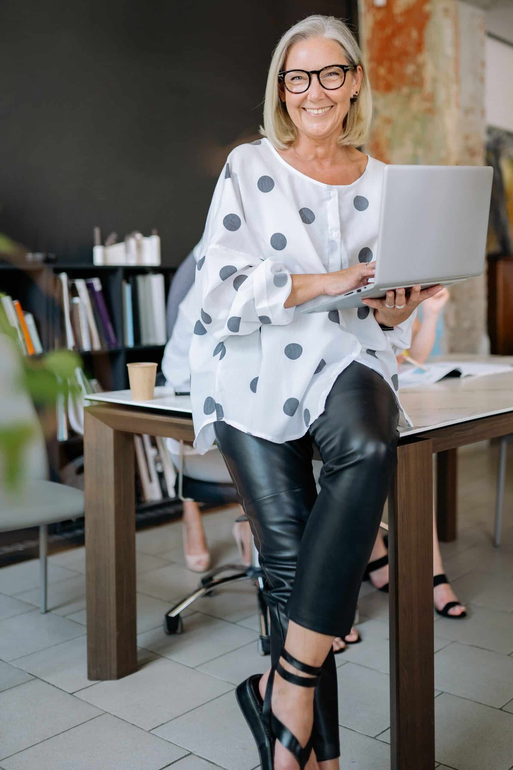 senior woman smiling while holding a laptop